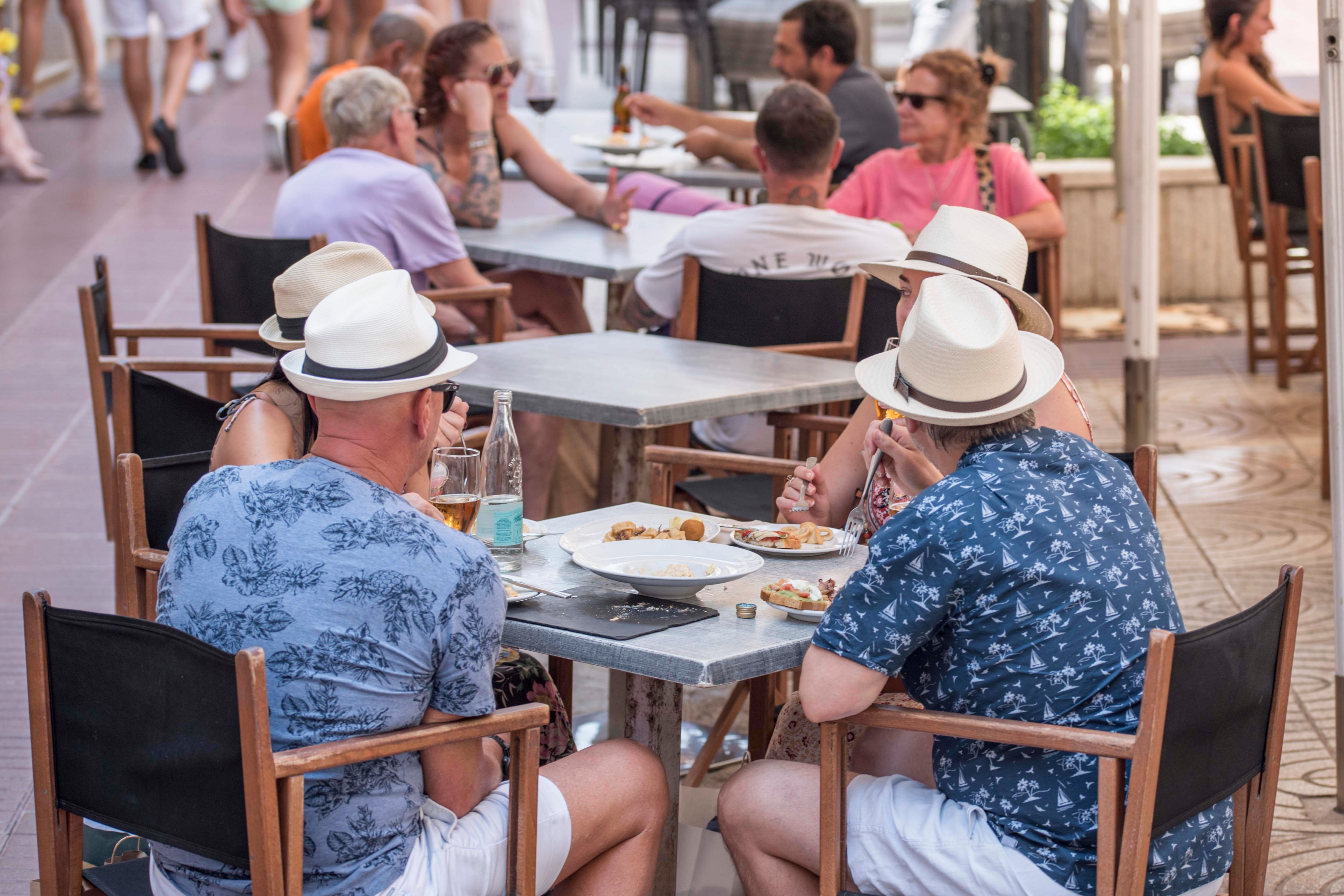 MAHÓN (MENORCA), 27/06/2023.- Turistas comen este martes en una terraza de Mahón (Menorca). El gasto medio diario de los turistas españoles dentro del país en el primer trimestre del año se situó en 79 euros por jornada, la misma cantidad que la media diaria de Baleares, según datos del INE. EFE/ David Arquimbau Sintes
