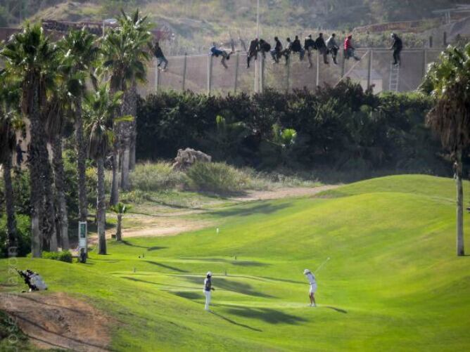 Varios inmigrantes saltan la valla de Melilla al lado de un campo de golf.