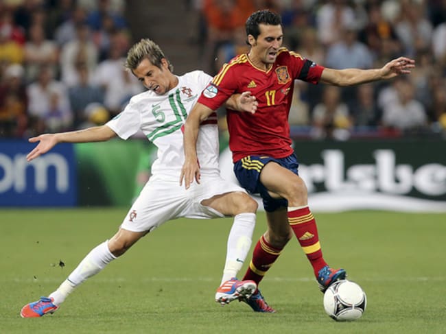 El defensa de la selección española Alvaro Arbeloa (d) pelea un balón con el defensa de Portugal Fabio Coentrao, durante la primera semifinal de la Eurocopa 2012, esta noche en el estadio Donbass Arena de Donetsk