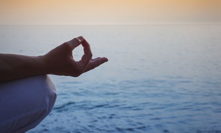 Practicante de yoga ante el mar