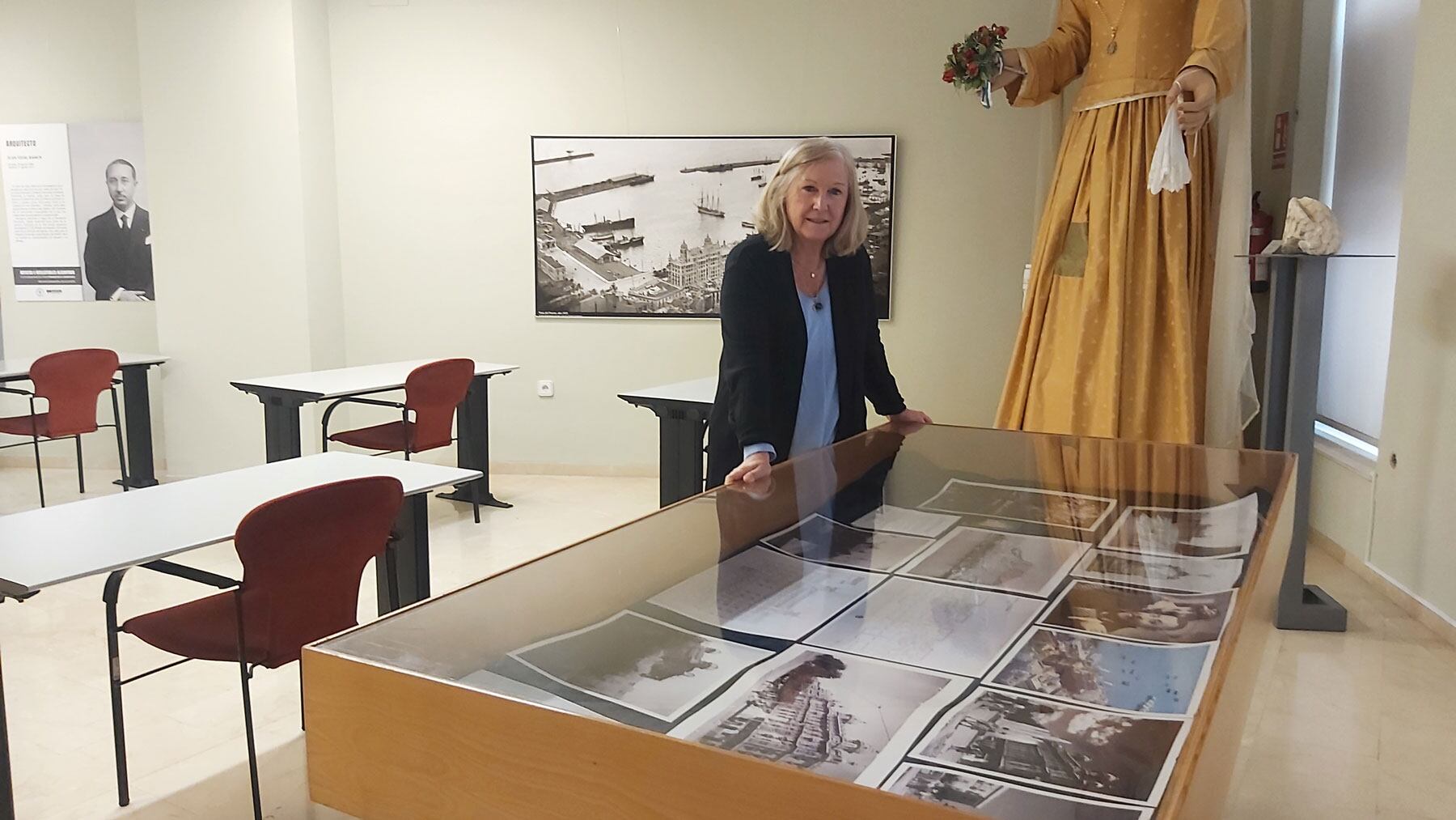 Susana Llorens, directora del Archivo Municipal de Alicante, ante la vitrina y los paneles de la exposición de los 100 años de la Casa Carbonell