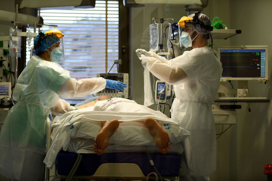 Personal sanitario atendiendo a un paciente de COVID-19 en la UCI. 