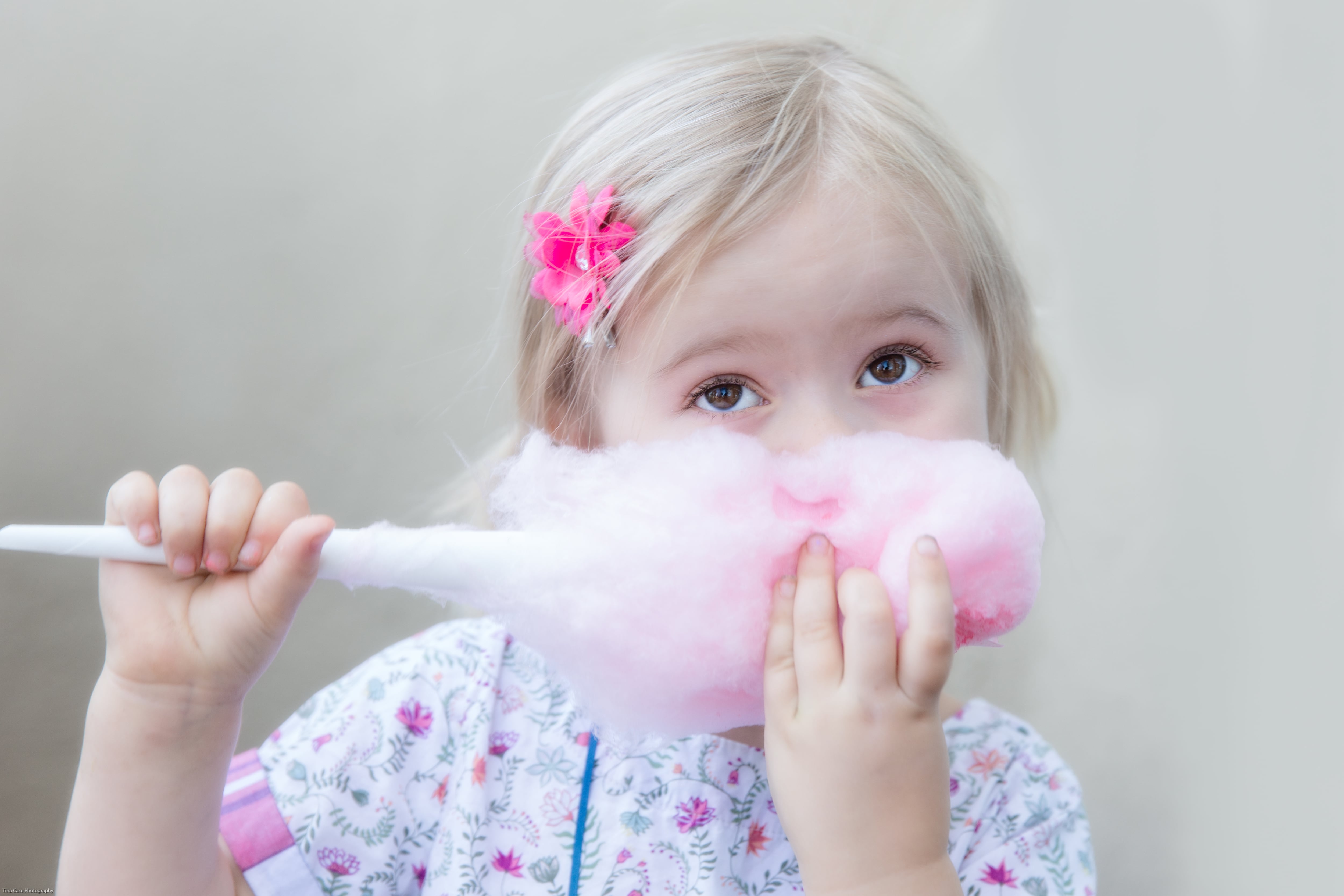 Una niña pequeña come algodón de azúcar