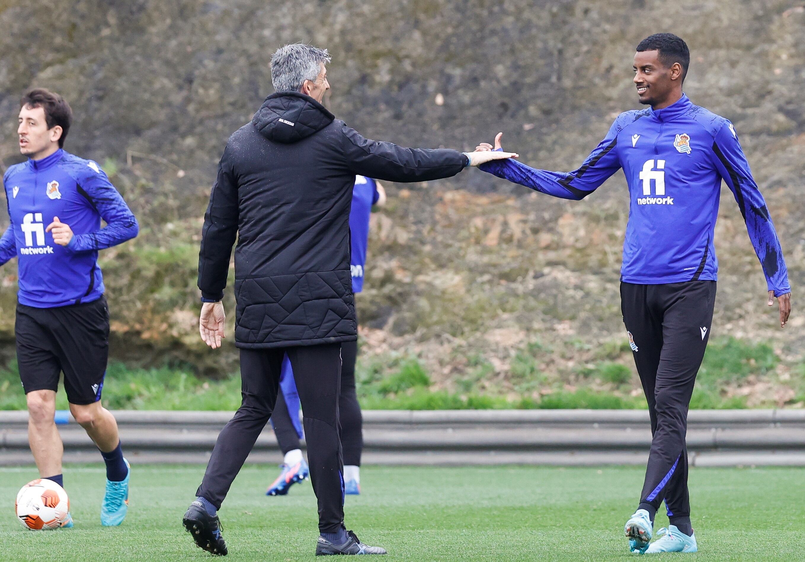 SAN SEBASTIÁN, 16/02/2022.-El entrenador de la Real Sociedad, Imanol Alguacil (c), saluda al delantero sueco Alexander Isak durante el entrenamiento que han celebrado este miércoles en el campo de Zubieta de San Sebastián, previo al encuentro de Liga Europa del jueves ante el Leipzig. EFE/Javier Etxezarreta