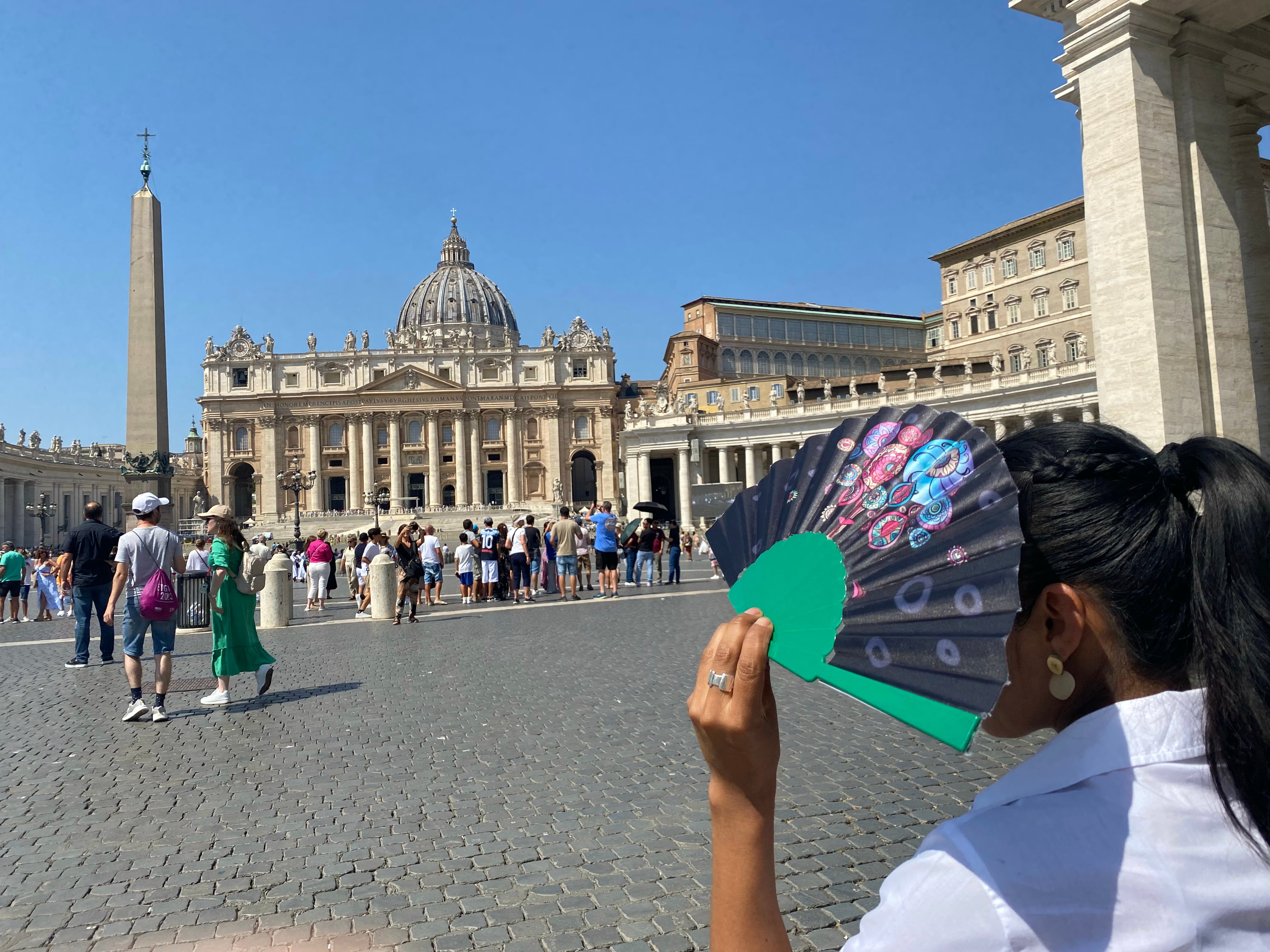 Una turista se protege del sol con un abanico en la Plaza de San Pedro. EFE/ Antonello Nusca