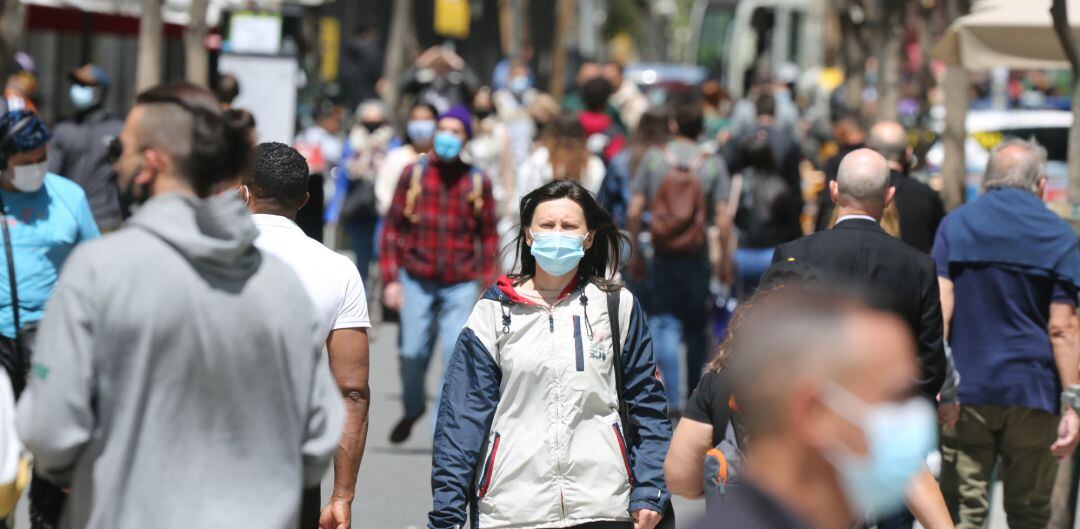 Varias personas caminan con mascarilla