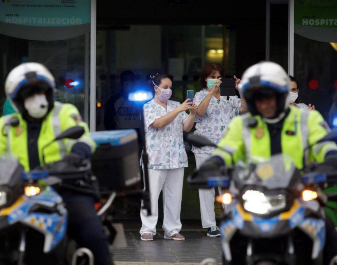 Miembros de las policías Local y Nacional, así como de Protección Civil, se congregaron esta sábado ante la puerta principal del Hospital Universitario de Canarias como muestra de apoyo al personal sanitario que atiende a enfermos por coronavirus