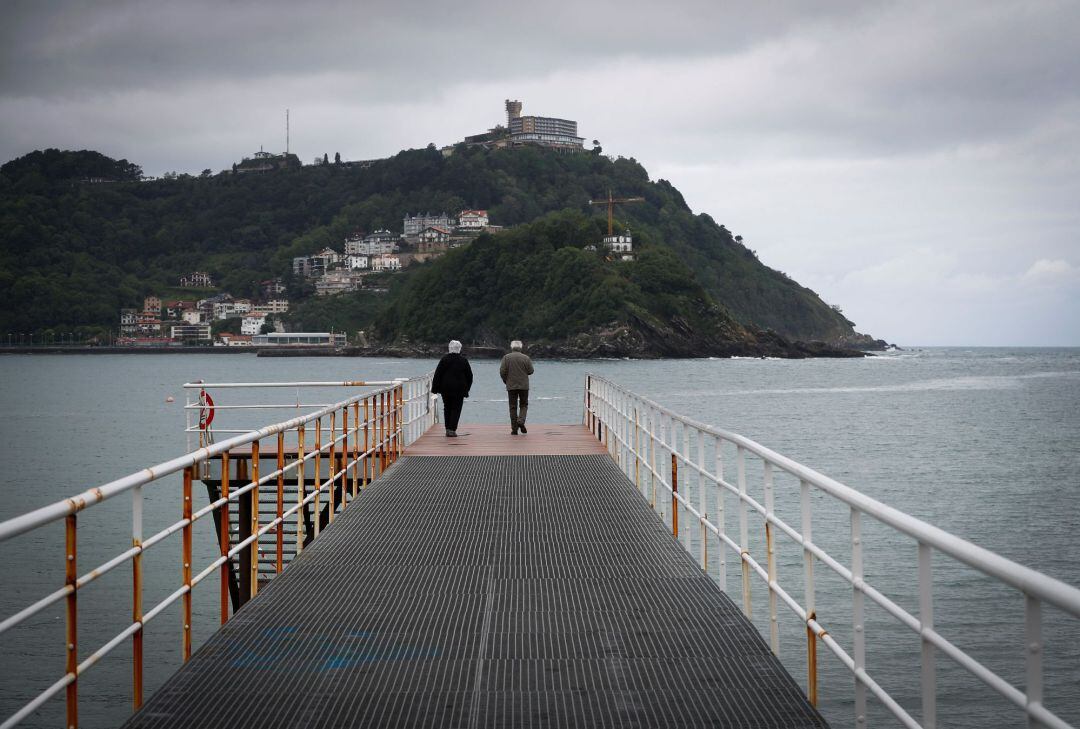 Dos personas mayores pasean por Donostia. 