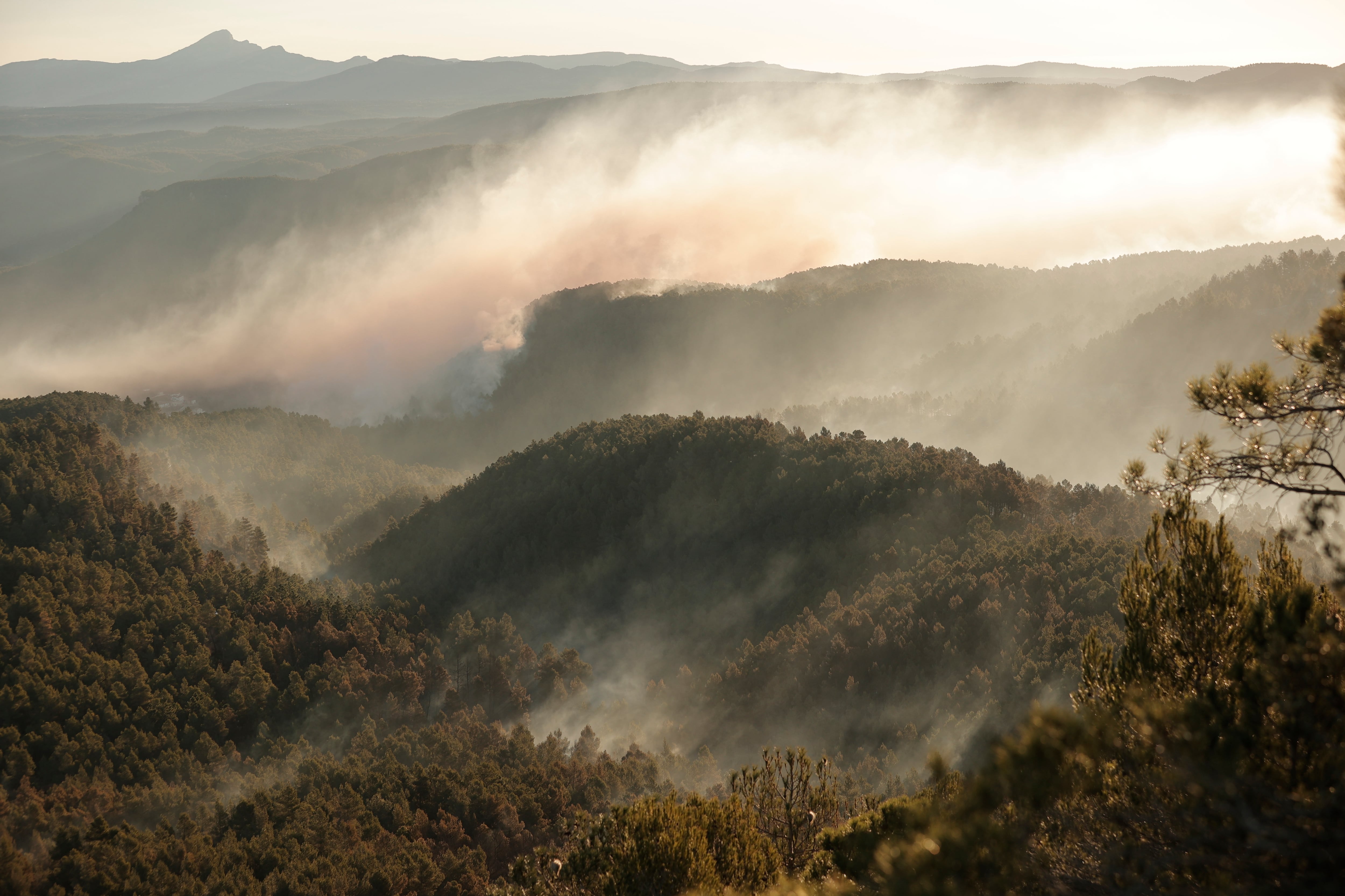 -FOTODELDIA- VILLANUEVA DE VIVER (CASTELLÓN), 25/03/2023.- Columnas de humo provocadas por el incendio a primera hora de este sábado en Villanueva de Viver, cerca de la aldea de los Peiros. Los trabajos desarrollados durante la noche por los medios de extinción han permitido que el perímetro del fuego del incendio forestal iniciado este jueves en el interior de Castellón, fijado en 40 kilómetros, no haya avanzado, según informa Emergencias de la Generalitat. En el incendio continúan trabajando este sábado más de 500 efectivos y se prevé que se incorporen alrededor de 20 medios aéreos durante la jornada. A primera hora de la mañana el fuego no había llegado hasta la carretera CV-195 y los medios de lucha contra el fuego indican que hay mucha humedad sobre el terreno. EFE/Manuel Bruque
