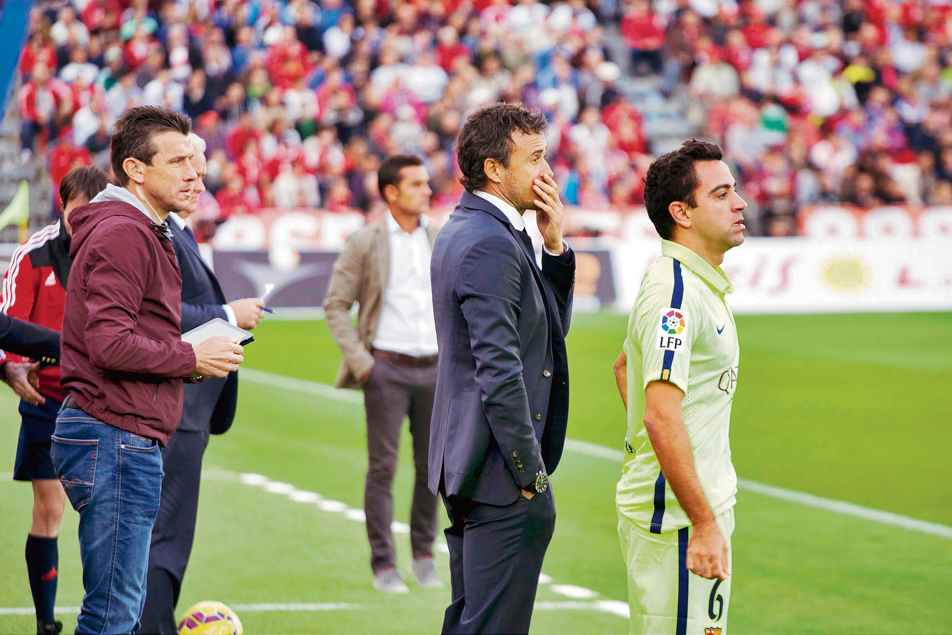 Unzué, Luis Enrique y Xavi en la banda de un campo de fútbol.