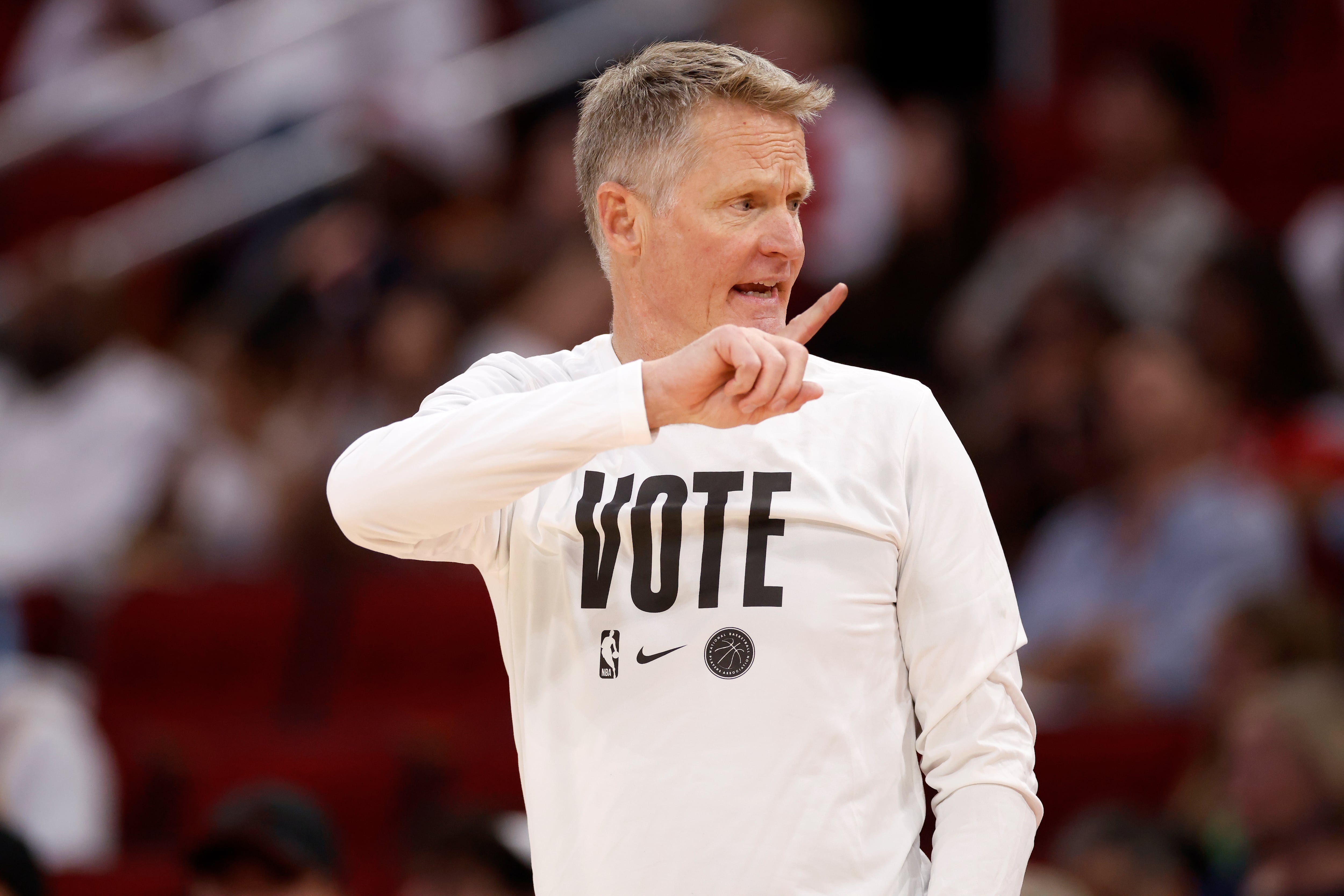 Steve Kerr luce una camiseta pidiendo el voto durante un partido de los Golden State Warriors