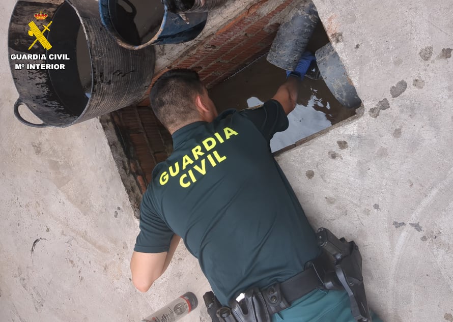 Un agente de la Guardia Civil inspecciona los vertidos del taller de Guadassuar