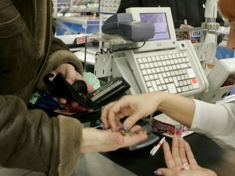 Una cajera ayuda a un cliente a contar las monedas de euro en un supermercado. EFE/Archivo