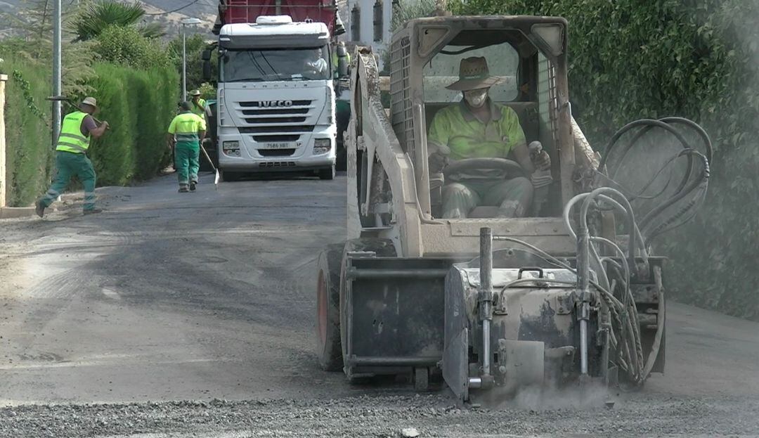 Maquinaria y operarios realizando labores de reasfaltado en el camino del Barrero