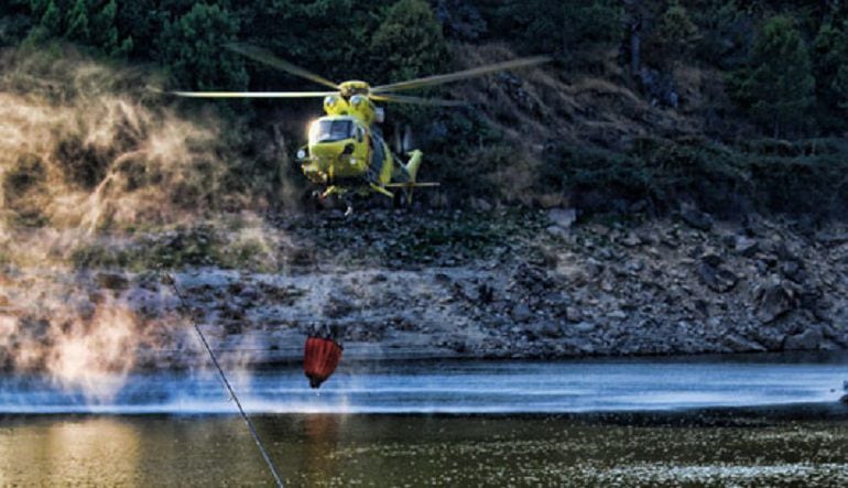 El helicóptero de la base del puerto del Pico carga agua en un embalse de la provincia