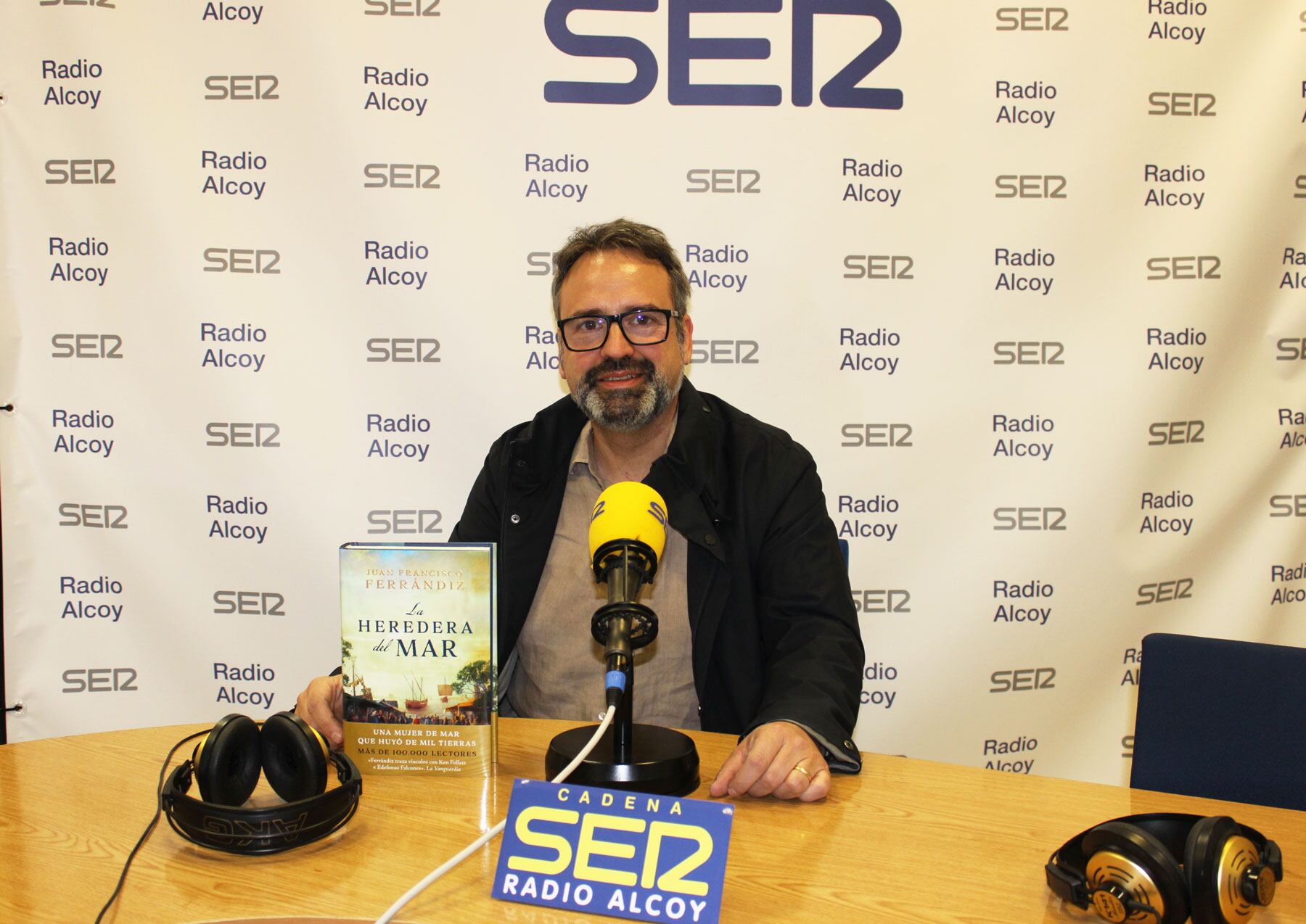 Juanfran Ferrandiz, en el estudio central de Radio Alcoy, cun ejemplar de su última novela histórica