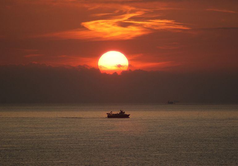 Un pesquero faena al atardecer