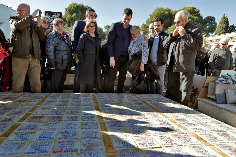 El secretario general del PSOE, Pedro Sánchez (c), ante una de las fosas comunes que hay en el cementerio de Paterna (Valencia)