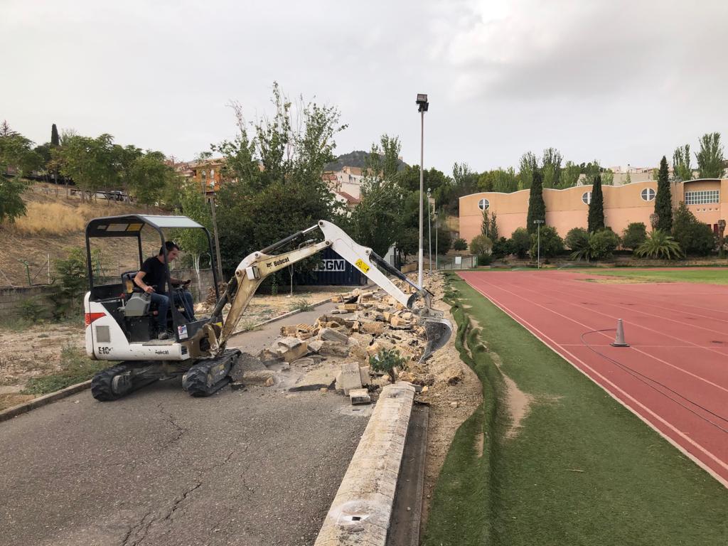 Un máquina   derriba el vallado  para comenzar las obras de la pista de 8 calles