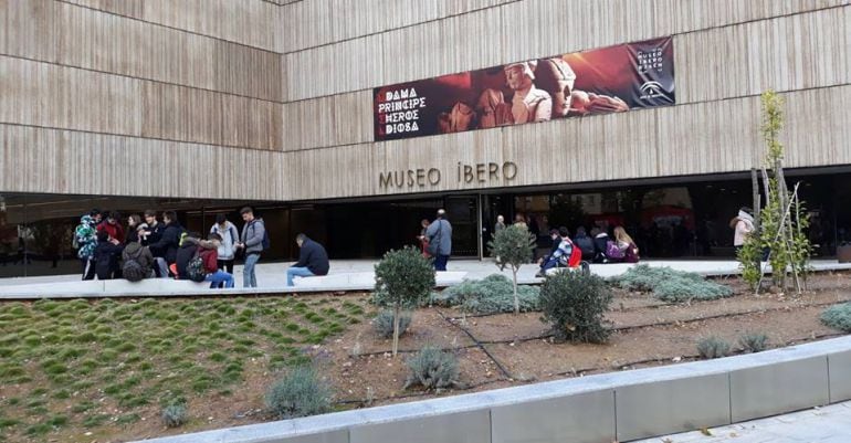 Un grupo de personas descansan a la entrada del Museo Íbero.