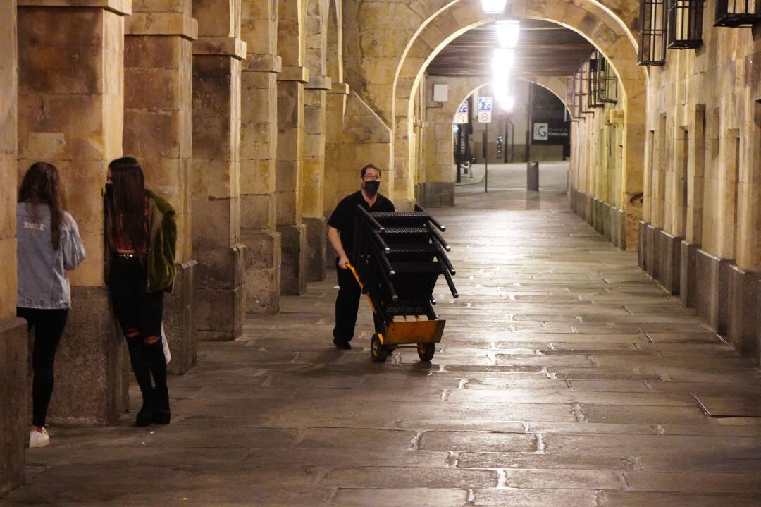 Un trabajador del entorno de la Plaza Mayor cierra su establecimiento ante el toque de queda.
