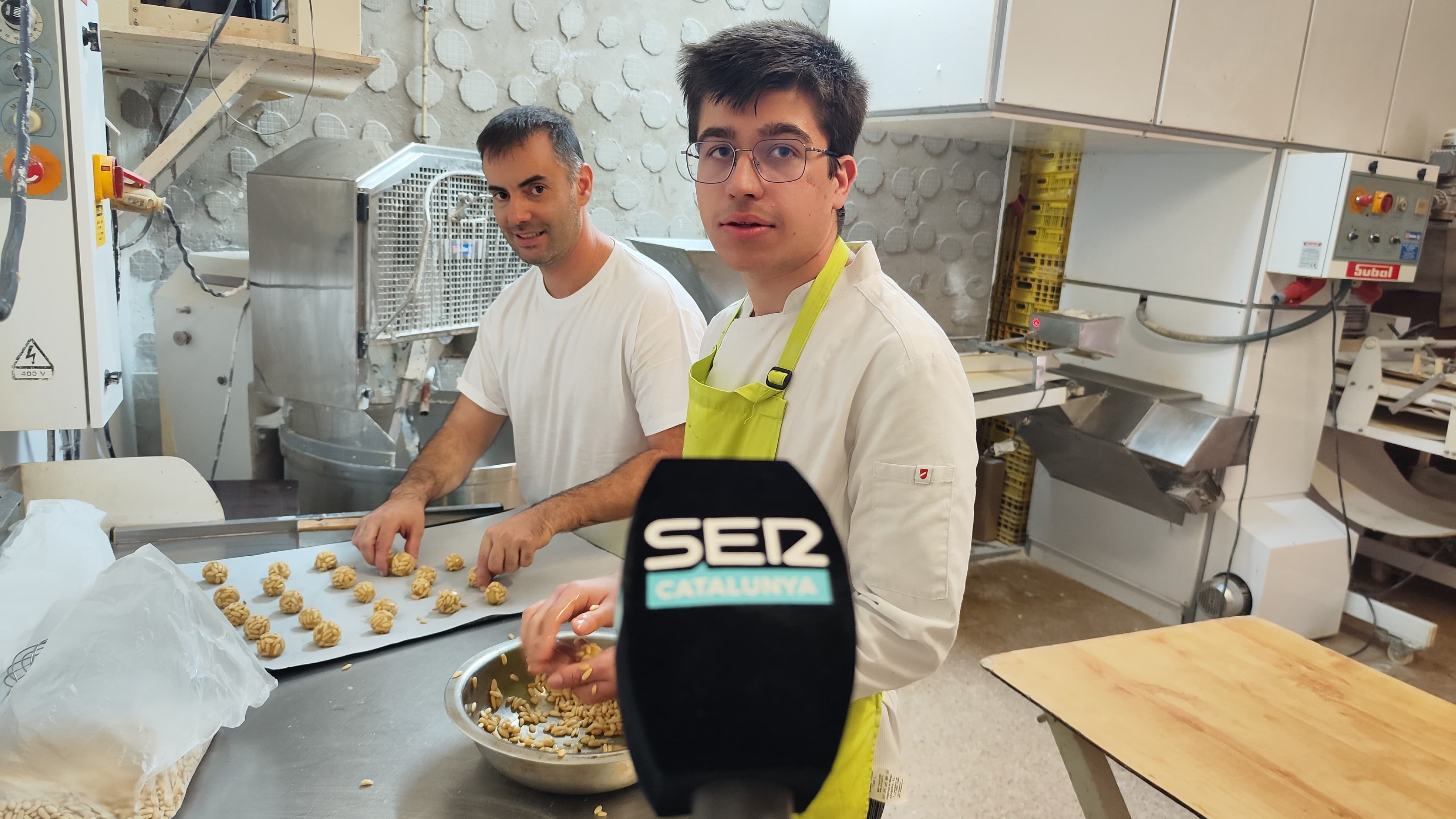 El forner Toni Frías preparant la plata de panellets abans de posar-la al forn. Al seu costat, l&#039;ajudant Xavier Fernández.