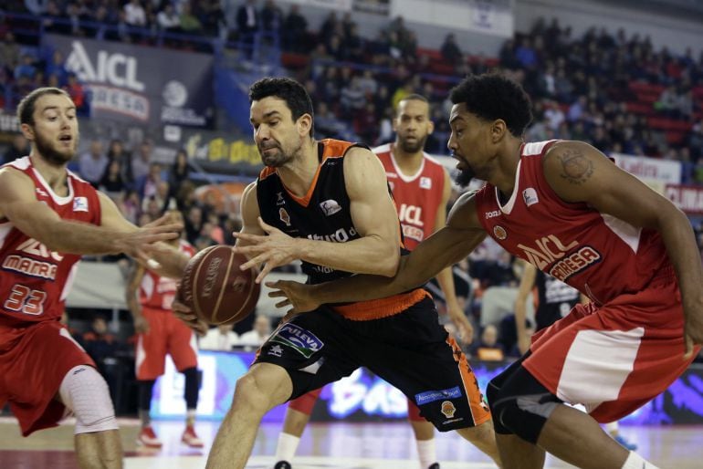 El escolta del Valencia Rafa Martínez intenta mantener el control ante la presión de los jugadores del Manresa Otverchenko (i) y Simon (d), durante el partido de la úndecima jornada de la fase regular de la Liga que ambos equipos disputaron en el pabellón Nou Congost de la localidad barcelonesa. 