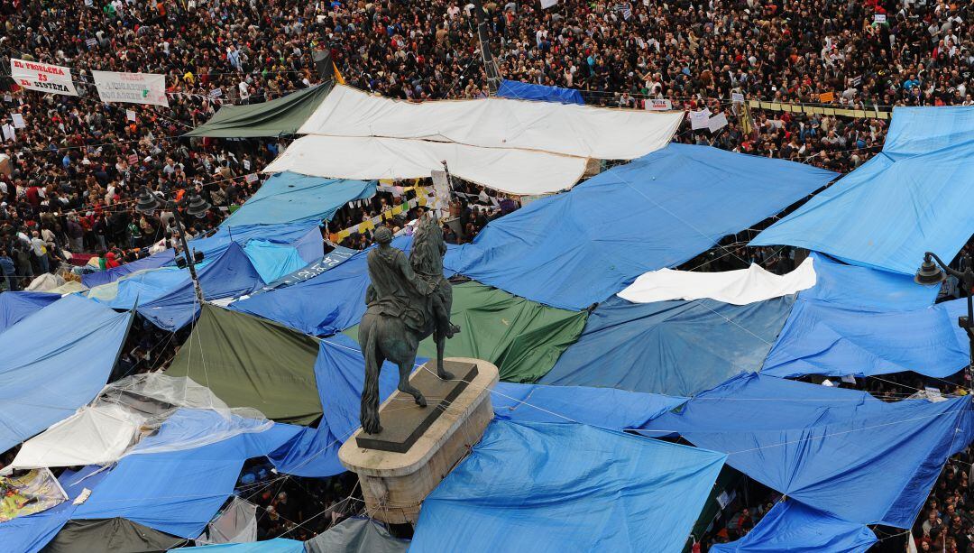 La estatua de Carlos III de la Puerta del Sol, rodeada de tiendas de campaña improvisadas y manifestantes el 19 de mayo de 2011.