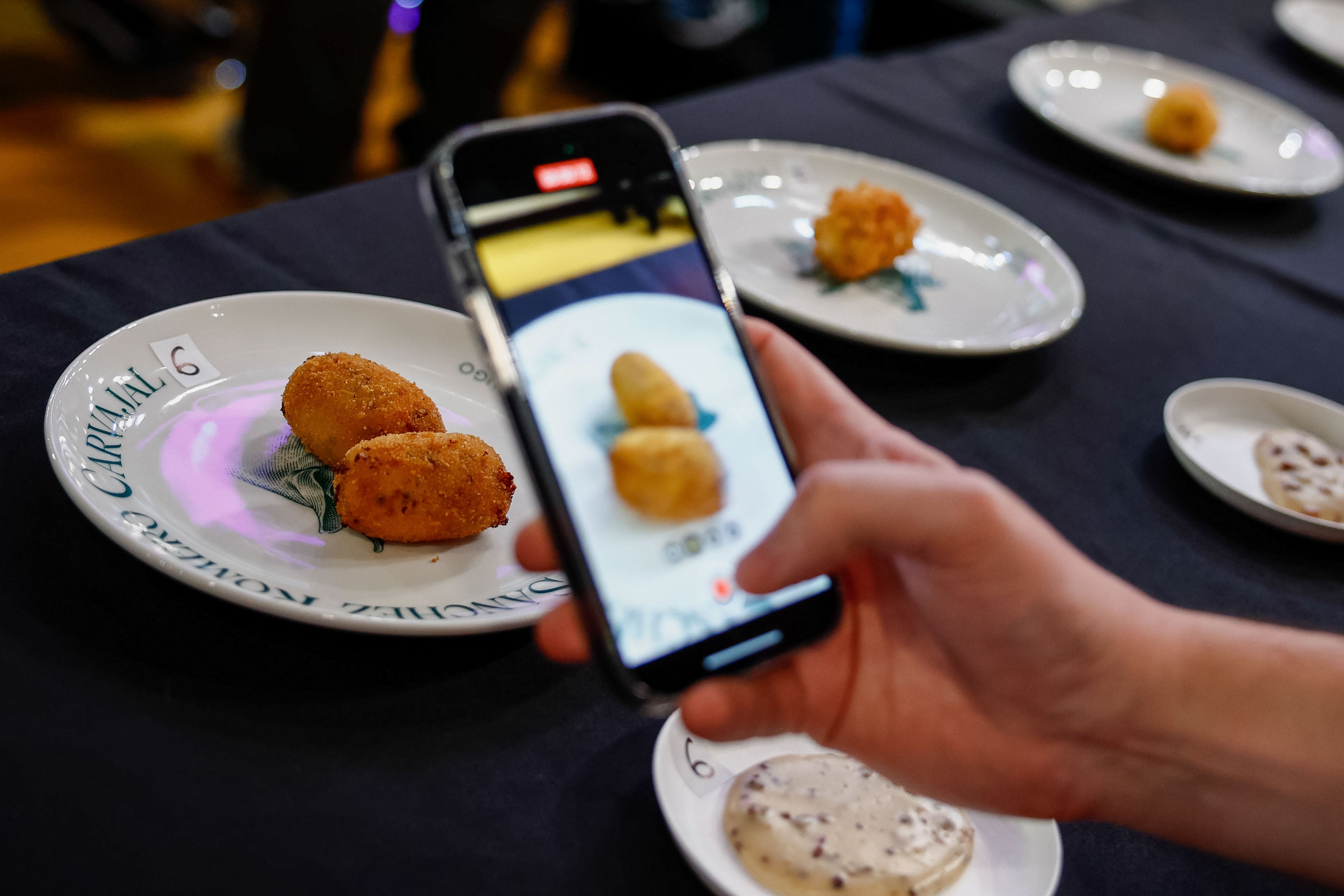 Un asistente fotografía un plato del concurso a  la mejor croqueta de jamón dentro de la vigesimotercera edición del congreso gastronómico Madrid Fusión, este lunes en Madrid.