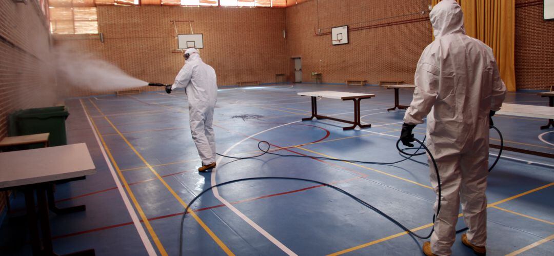 Una dotación de bomberos desinfecta uno de los pabellones