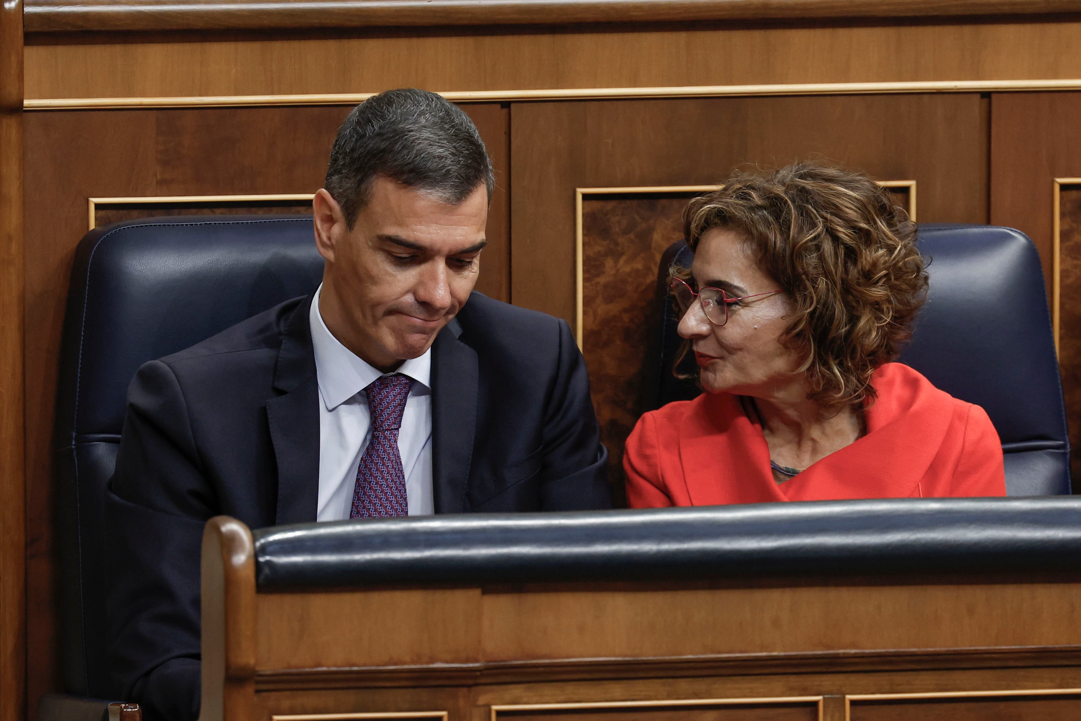 El presidente del Gobierno, Pedro Sánchez y la vicepresidenta primera y ministra de Hacienda, María Jesús Montero, conversan durante su asistencia al pleno del Congreso de los Diputados este miércoles.