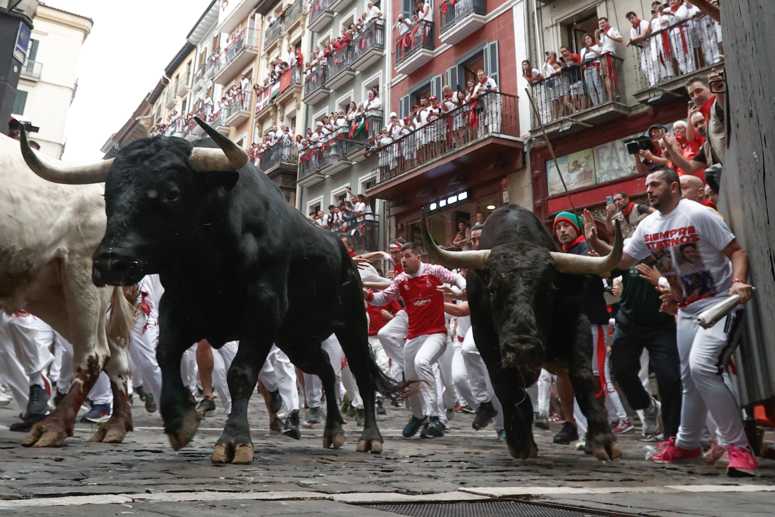 Mozos perseguidos por los toros de Victoriano del Río en el tercer encierro de los Sanfermines este martes, en Pamplona