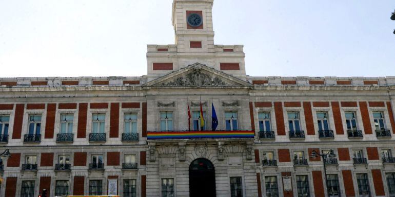 GRA087. MADRID, 28/06/2015.- Una gran bandera arcoíris luce desde primera hora de esta mañana en el balcón principal de la Real Casa de Correos de la Puerta del Sol, sede de la Presidencia de la Comunidad de Madrid, con motivo de la celebración hoy del Dí