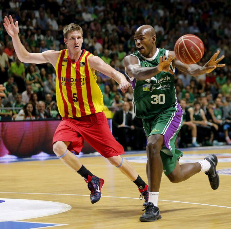 GRA602. MÁLAGA, 10/06/2015.- El ala-pívot estadounidense de Unicaja Caleb Green (d) pasa el balón ante su compatriota Justin Doellman, del FC Barcelona, durante el tercer partido de la semifinal de la Liga Endesa de baloncesto que se disputa esta noche en el Palacio de Deportes José María Martín Carpena, en Málaga. EFE/Jorge Zapata