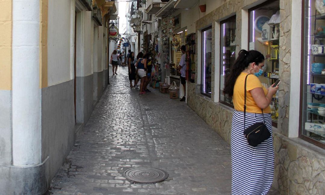 Una mujer con mascarilla por el centro de Tarifa.