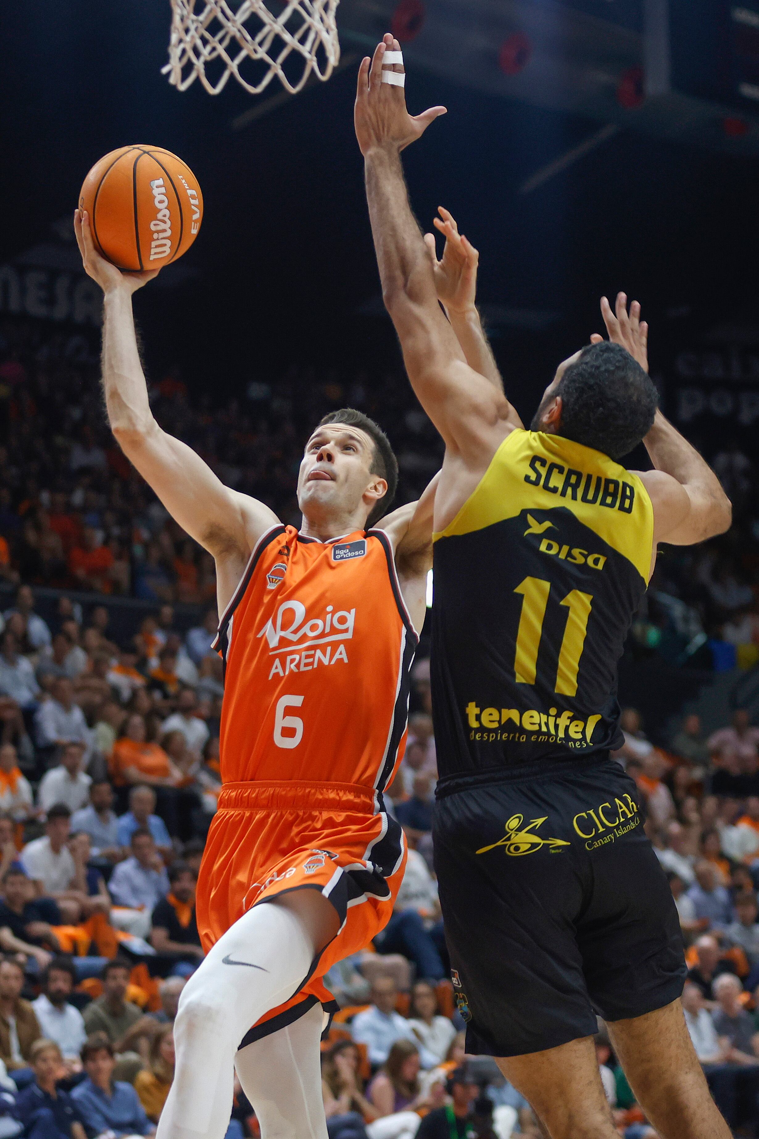 VALENCIA, 10/06/2025. El jugador de Valencia Basket, Xabi López-Aróstegui (i), entra a canasta ante el jugador canadiense de La Laguna Tenerife, Thomas Scrubb, durante el primer encuentro de las semifinales de la Liga Endesa que disputan hoy martes en el pabellón de la Fuente San Luis de Valencia. EFE/Miguel Ángel Polo.
