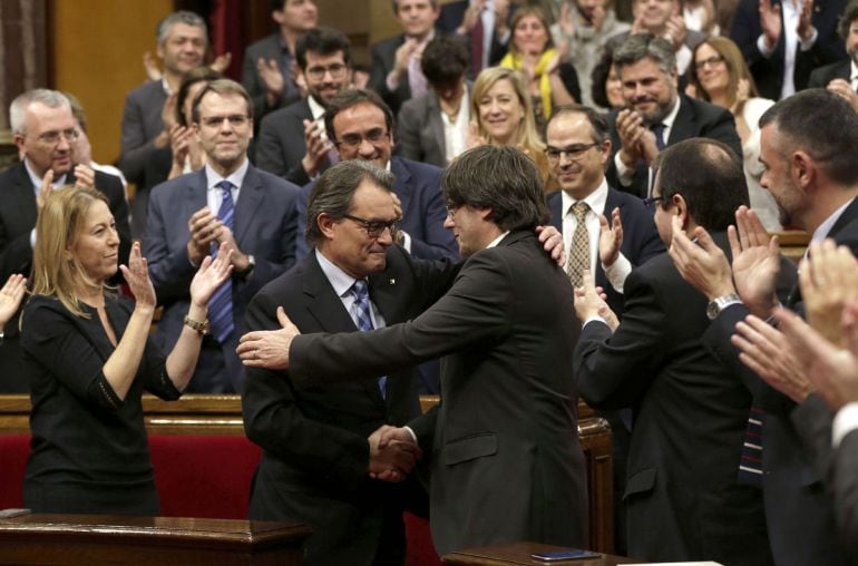 El expresidente de la Generalitat en funciones, Artur Mas (i), felicita a su sucesor, Carles Puigdemont (d), tras ser elegido nuevo presidete catalán