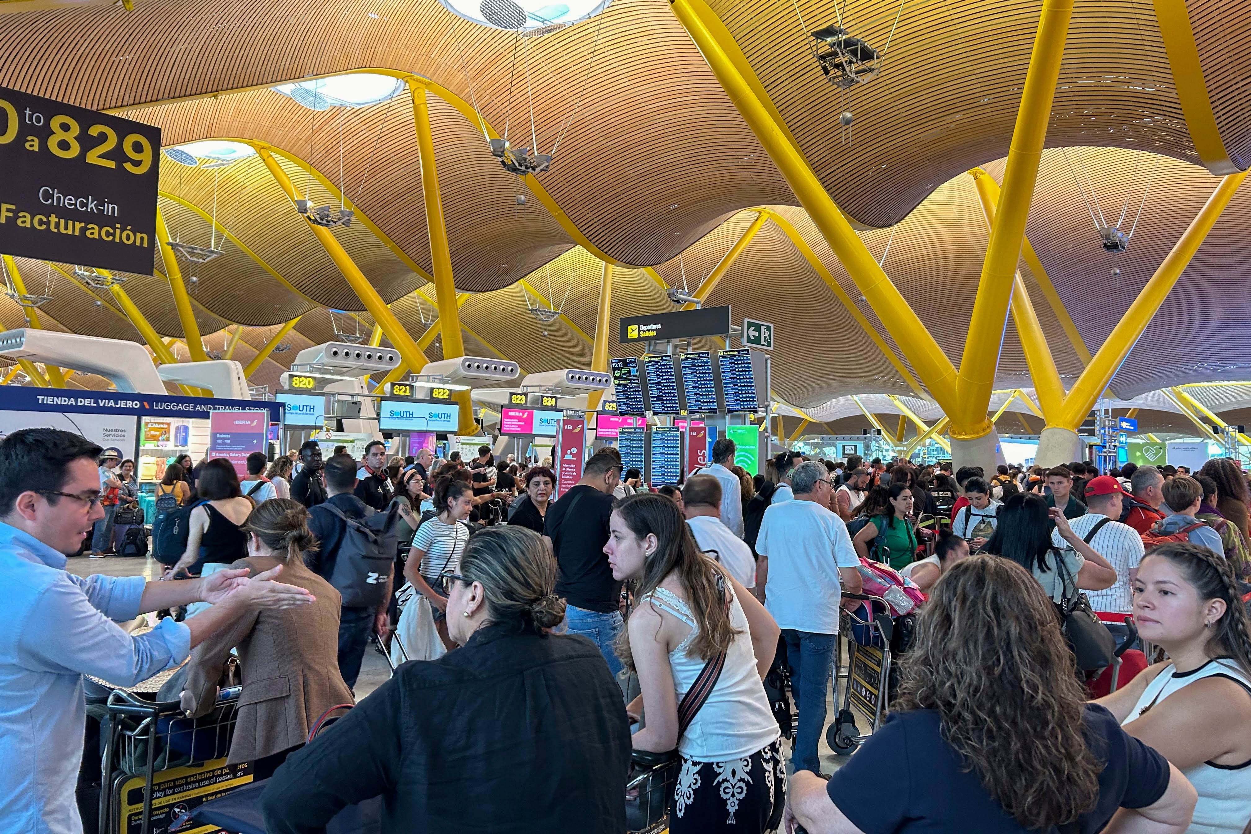 Varias personas hacen cola en la zona de facturación de la T-4 del Aeropuerto Adolfo Suárez de Madrid tras la incidencia global de Microsoft.