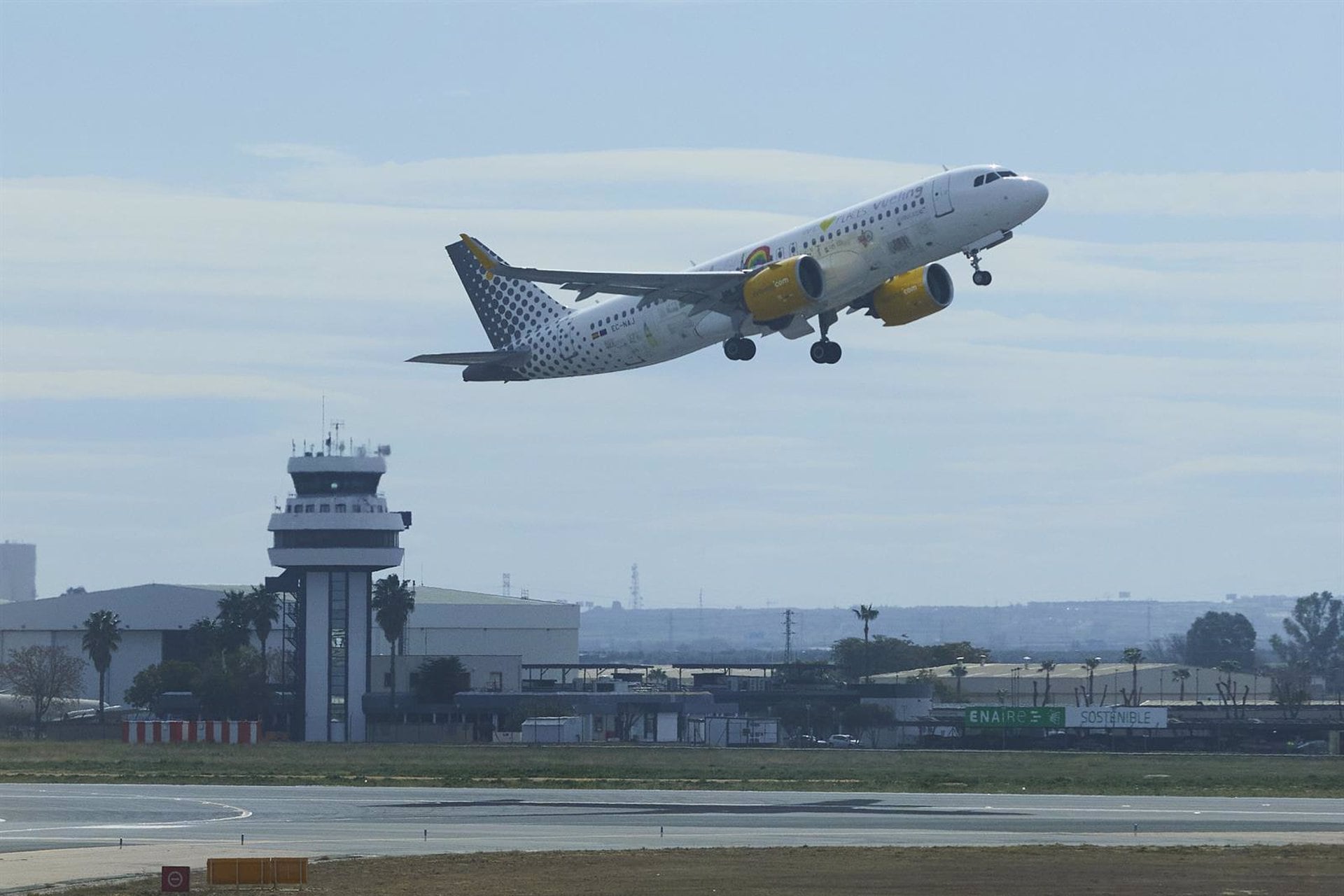 Un avión despega y al fondo la torre de control durante la presentación de la remodelación y ampliación del Aeropuerto de Sevilla/Joaquín Corchero