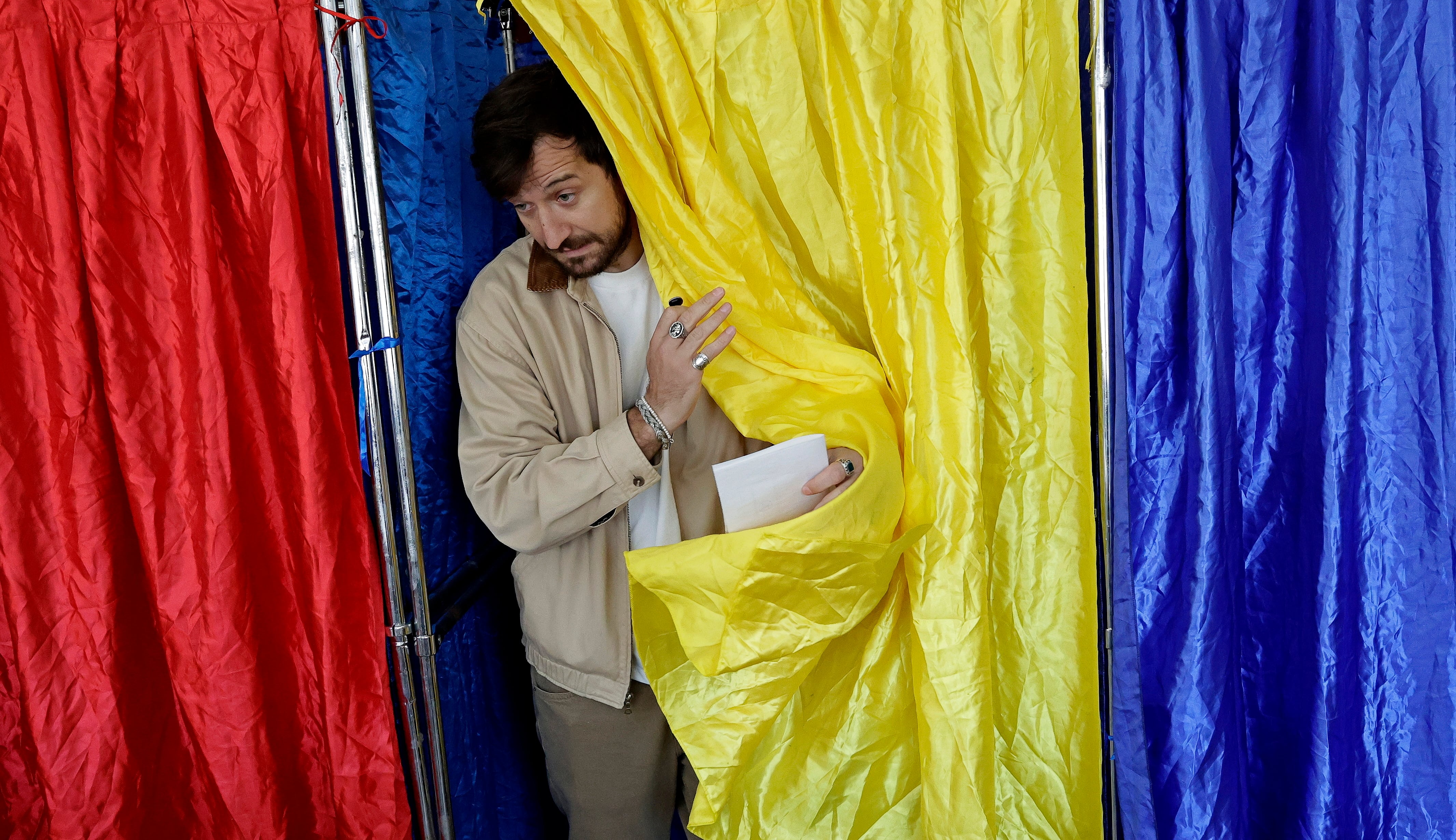 Un votante sale de una cabina en un colegio electoral de Bucarest