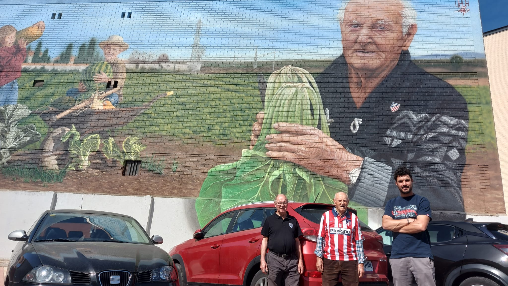 Celestino junto a su hijo y el autor del mural, Christian 'Sasa'