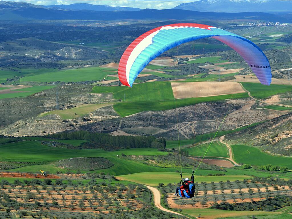 Imagen de archivo de una persona sobrevolando en parapente el paraje de la Muela, en Alamilla (Guadalajara)