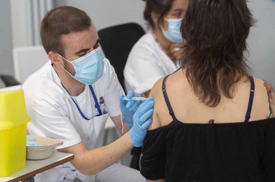 Archivo - Una joven recibe una dosis de la vacuna contra el Covid