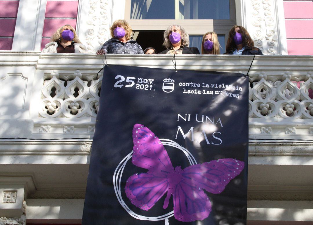 Autoridades colgando la pancarta conmemorativa del 25-N en el balcón del Museo Cristina García Rodero