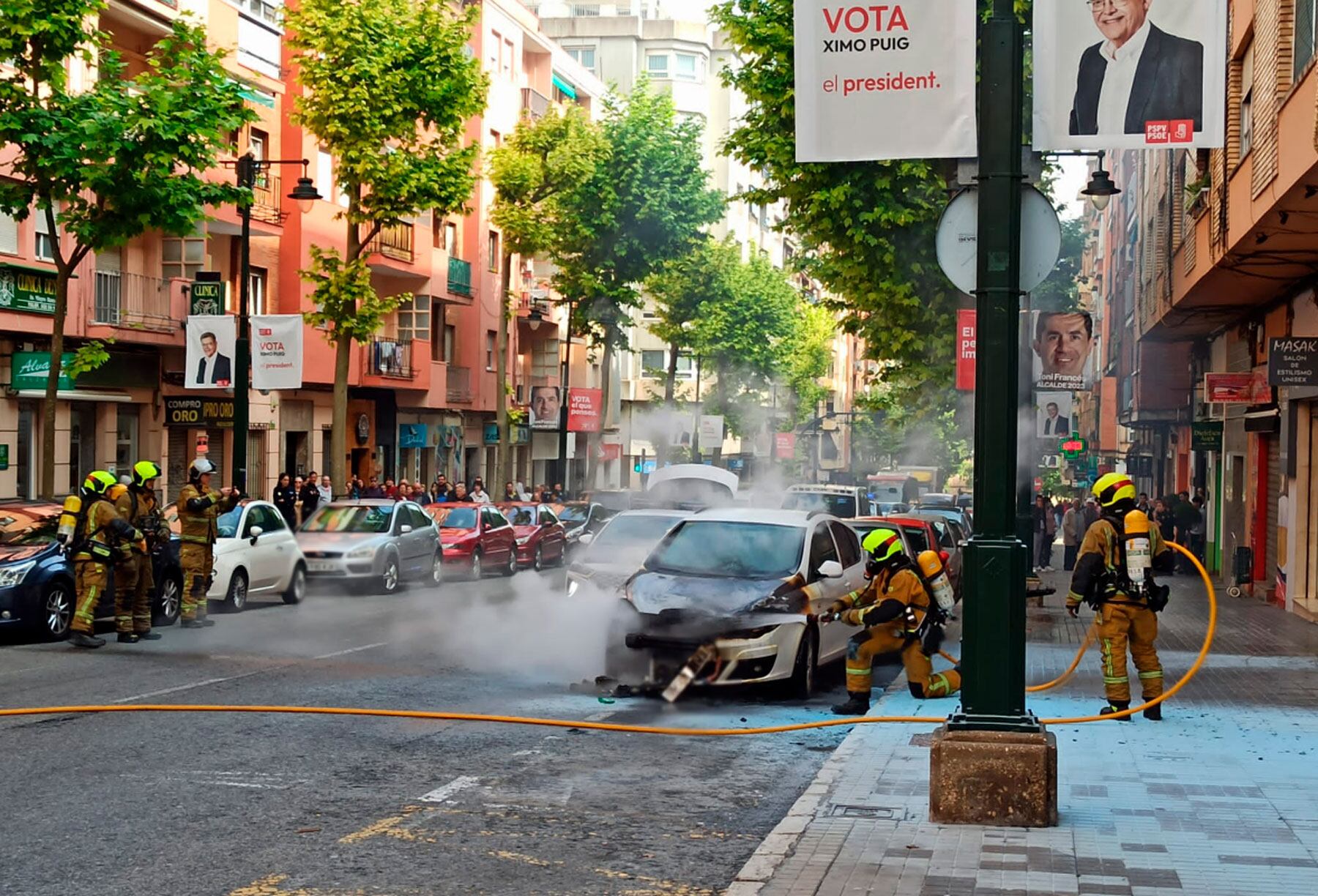 Los bomberos apagando el vehículo en llamas en la calle Santa Rosa