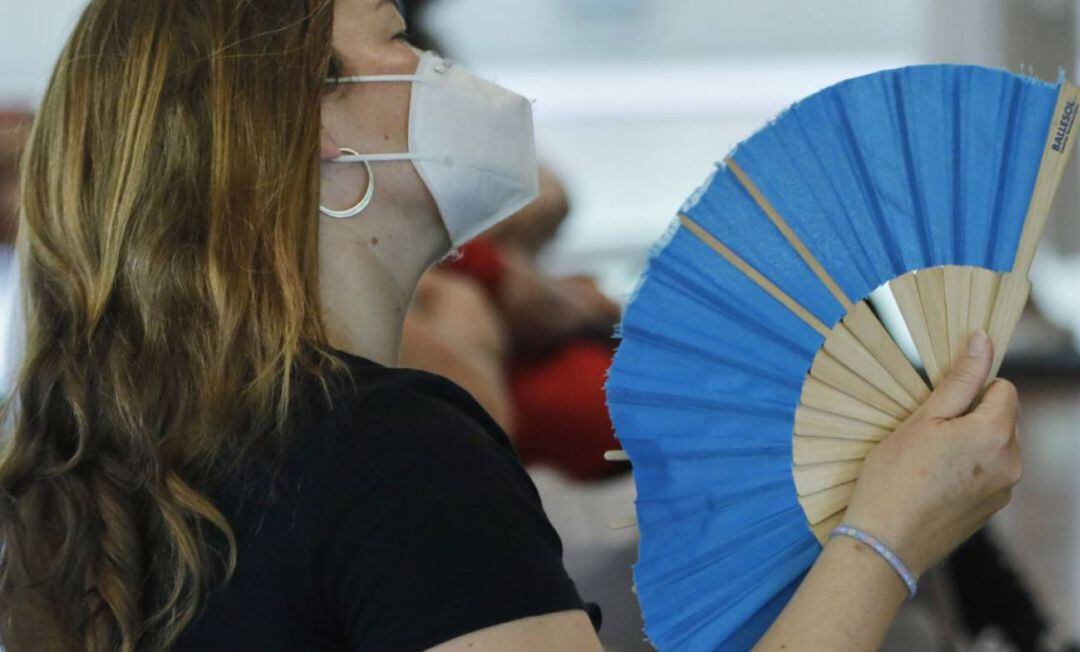 Una mujer con mascarilla se abanica en Madrid