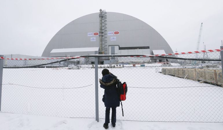 Un periodista, ante el sarcófago protector colocado sobre el cuarto reactor de la central nuclear de Chernóbil.