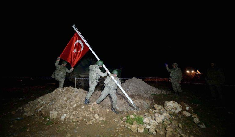 TUR07. Aleppo (Syria), 22/02/2015.- Turkish soldier place a Turkish flag as they are on the way to the tomb of Suleyman Shah for an evacuate operation near Aleppo, Syria early 22 February 2015. A historic Ottoman tomb and the dozens of Turkish troops who