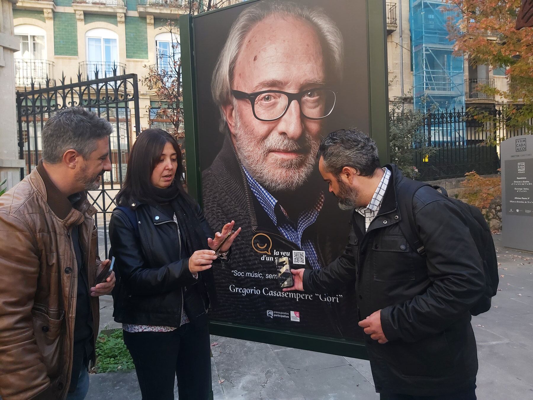 Toni Miranda, Teresa Sanjuan y Raül Llopis consultan el código QR en el mupi ubicado en el IVAM CADA Alcoi