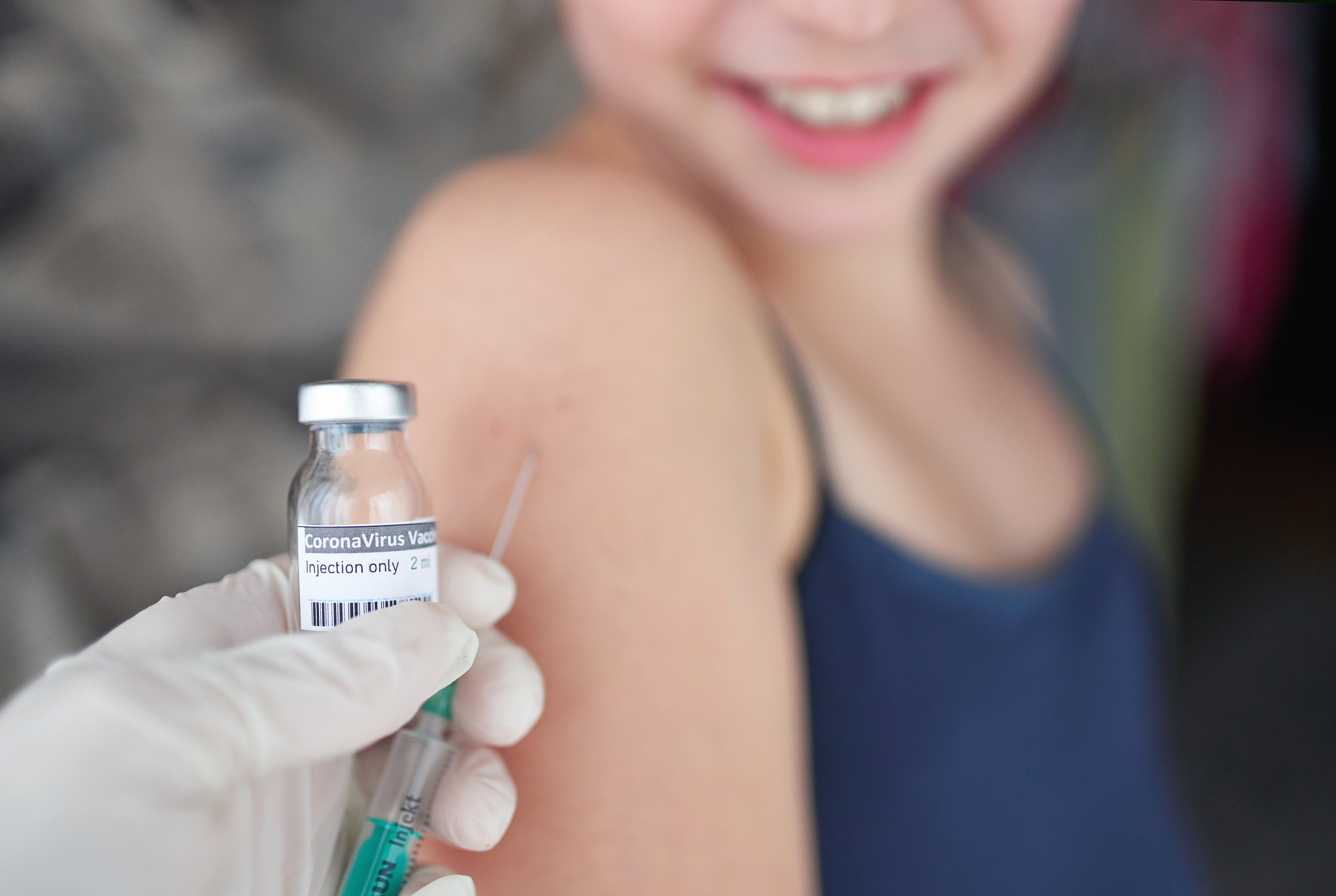 Midsection of child with face mask getting vaccinated, coronavirus, covid-19 and vaccination concept.